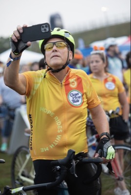 Rider taking a selfie in a "Hope Rides With Me" survivor jersey at the ride